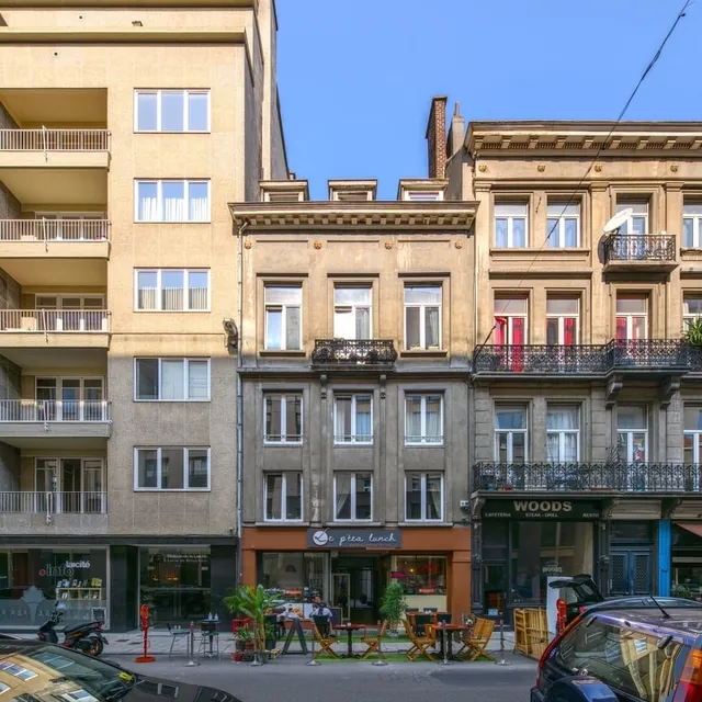Immeuble étroit de trois niveaux avec commerce en rez-de-chaussée, encadré par deux immeubles plus hauts, avant travaux
